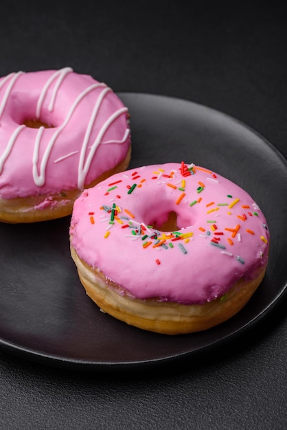 Delicious donut with cream filling and nuts on a dark concrete background