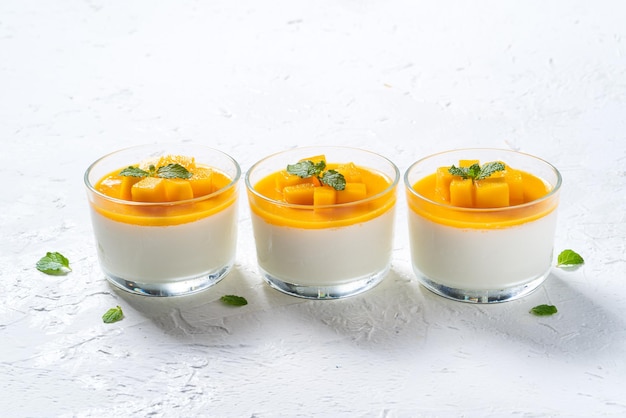 Delicious double colored mango panna cotta mousse pudding on white table background