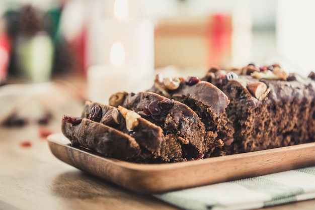 Delicious dried mixed nut Christmas fruit cake on wooden plate 