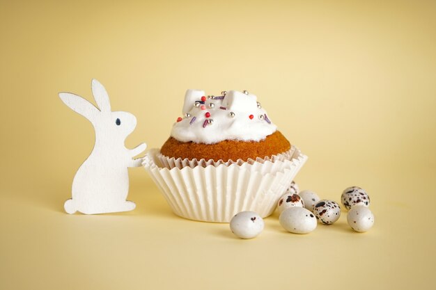 Delicious Easter cupcake on yellow background with bunny toy