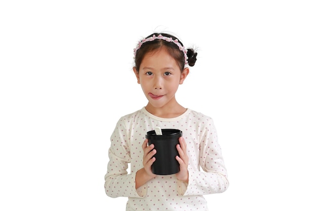 Delicious eating expression Asian young girl hold and eat food from black cup isolated on white background