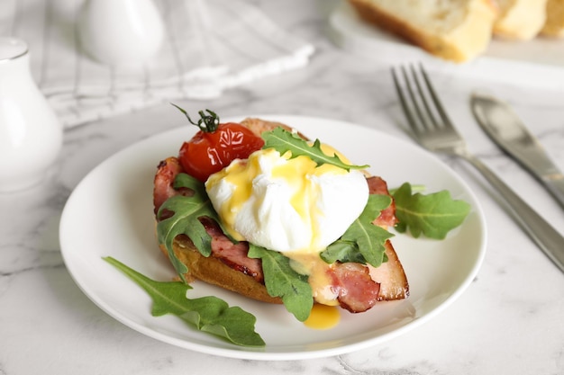 Delicious egg Benedict served on white marble table