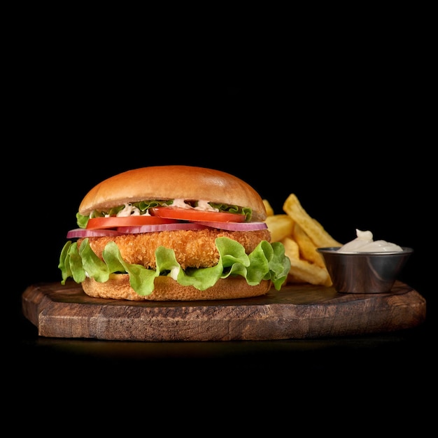 Delicious fastfood fresh tasty burger crispy breaded chicken burger with and vegetable on wooden cutting board