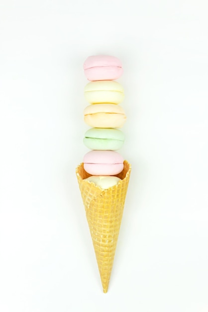 Delicious in the form of a waffle cone filled marshmallows looks like macaroons on a white background