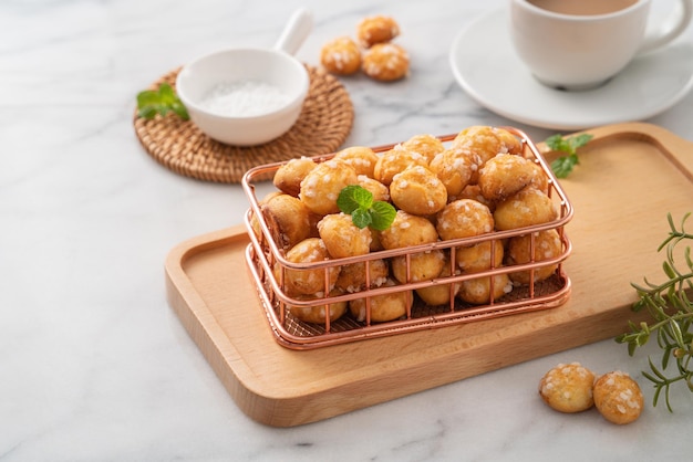 Delicious French Chouquette Choux Pastry dessert Pearl Sugar Puff on white marble background