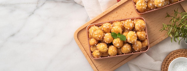 Delicious French Chouquette Choux Pastry dessert Pearl Sugar Puff on white marble background