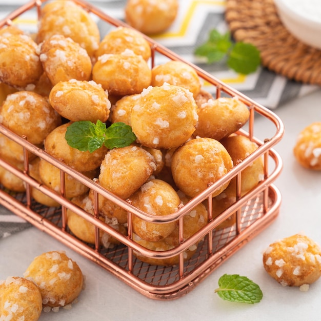 Delicious French Chouquette Choux Pastry dessert Pearl Sugar Puff on white marble background