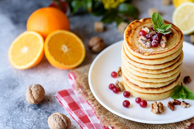 Delicious fresh beautiful pancakes with citrus honey and jam. Delicious hot breakfast with pancakes with fruit and berries