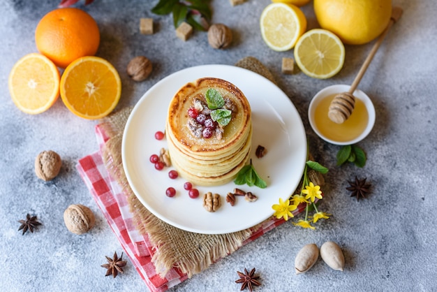 Delicious fresh beautiful pancakes with citrus honey and jam. Delicious hot breakfast with pancakes with fruit and berries