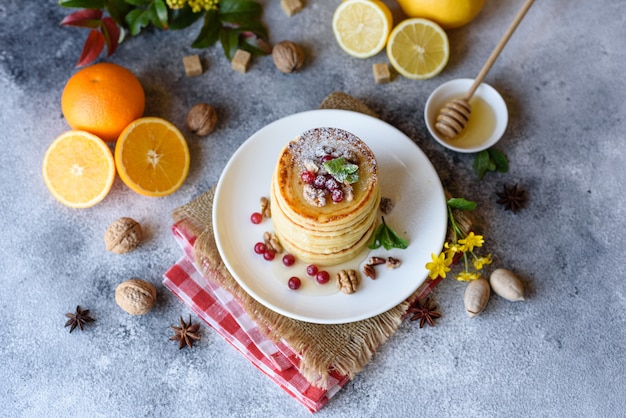 Delicious fresh beautiful pancakes with citrus honey and jam. Delicious hot breakfast with pancakes with fruit and berries