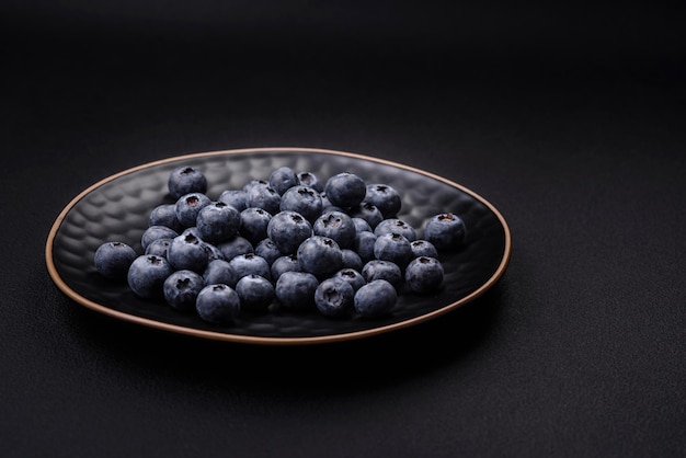 Delicious fresh blueberries on a textural black concrete background