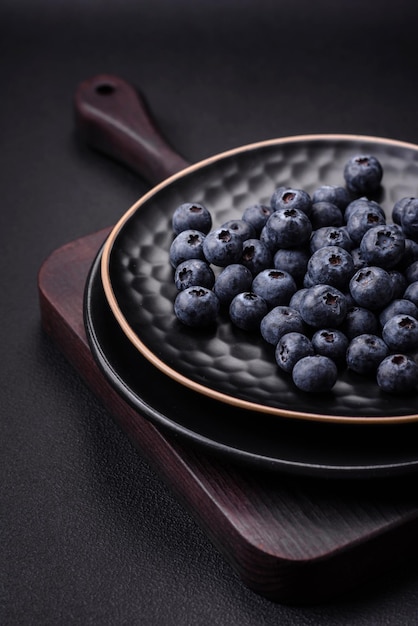 Delicious fresh blueberries on a textural black concrete background