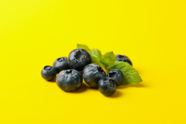 Delicious fresh blueberry on yellow background, space for text