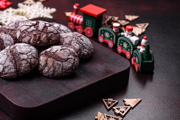 Delicious fresh brownies with Christmas decorations on a dark concrete background