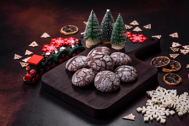 Delicious fresh brownies with Christmas decorations on a dark concrete background