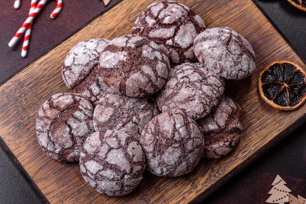 Delicious fresh brownies with Christmas decorations on a dark concrete background