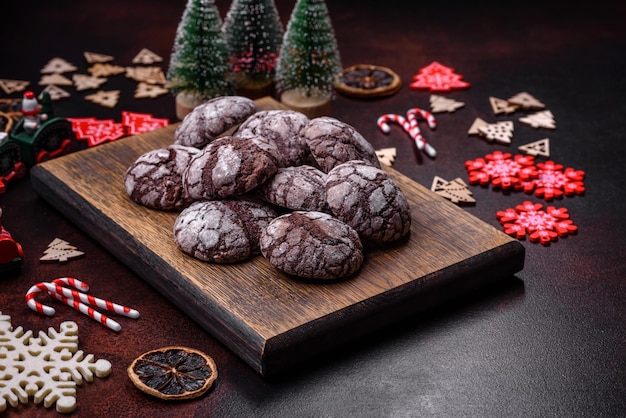 Delicious fresh brownies with Christmas decorations on a dark concrete background