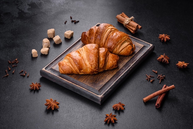 Delicious fresh crispy croissants on a dark concrete background. Tasty breakfast