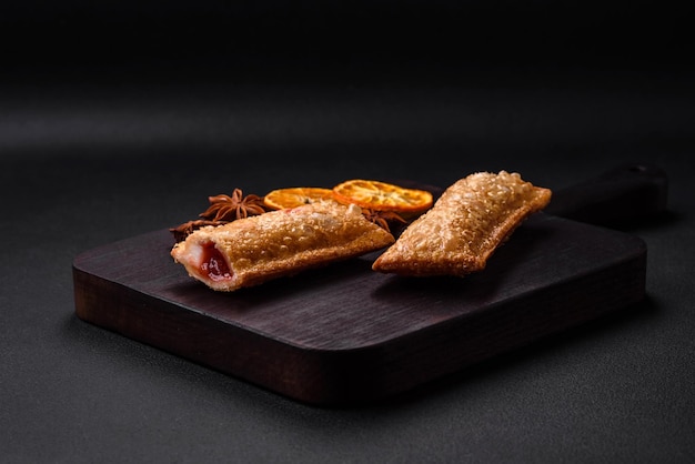 Delicious fresh crispy pie with cherry jam on a wooden cutting board