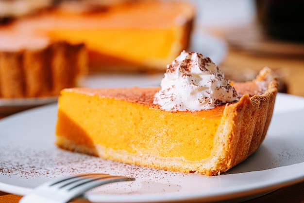 Delicious Fresh Homemade Thanksgiving Pumpkin Pie with a sliced wedge ready to be eaten