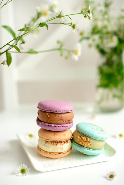 Delicious fresh macaroons with filling on a light wooden background