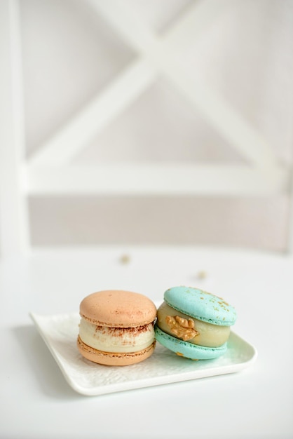 Delicious fresh macaroons with filling on a light wooden background