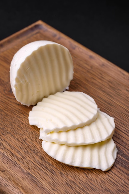 Delicious fresh mozzarella cut into slices on a wooden cutting board