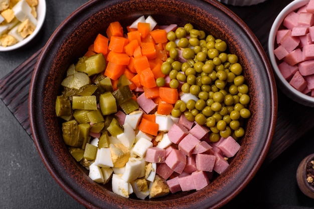 Delicious fresh Olivier salad with sausage egg cucumber green peas carrots and mayonnaise