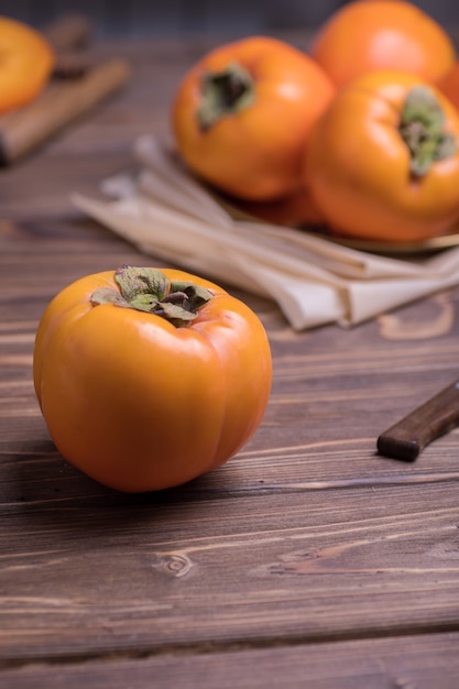 Photo delicious fresh orange persimmon fruit on wooden table with knife