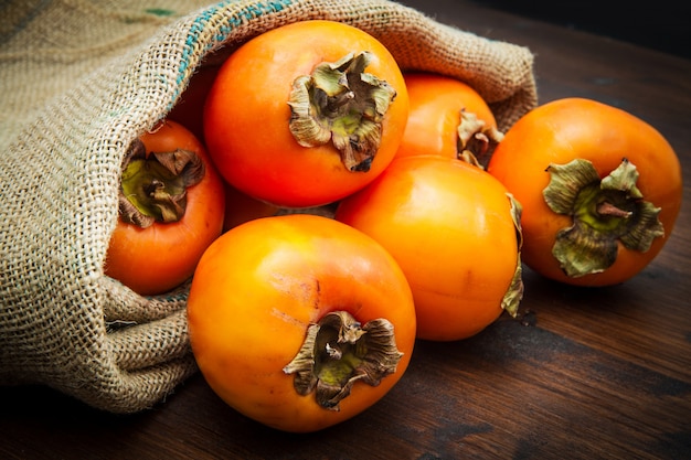 Delicious fresh persimmon fruit on wooden table