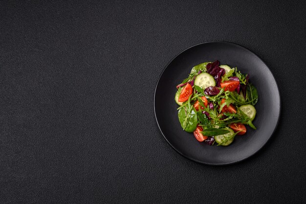 Delicious fresh salad with arugula spinach cucumber and cherry tomatoes in a ceramic plate