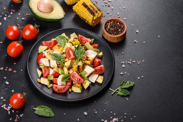 Delicious fresh salad with tomatoes, avocado, cheese and grilled corn with olive oil. Mediterranean cuisine