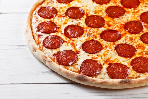 Delicious fresh salami pizza served on wooden table