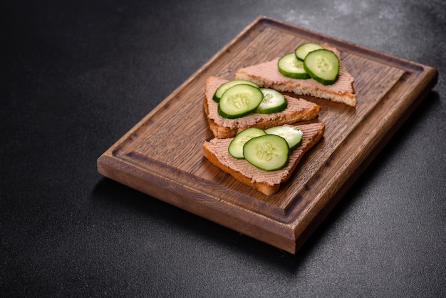 Delicious fresh sandwich with chicken liver pate with crispy toast butter and cucumber