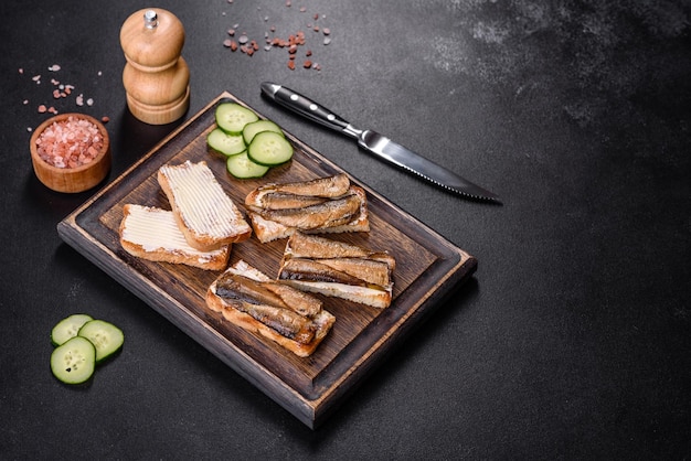 Delicious fresh sandwich with sprats with crispy toast butter and cucumber