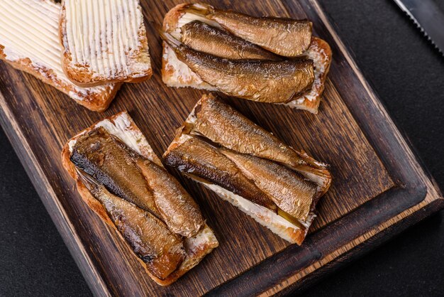 Delicious fresh sandwich with sprats with crispy toast butter and cucumber