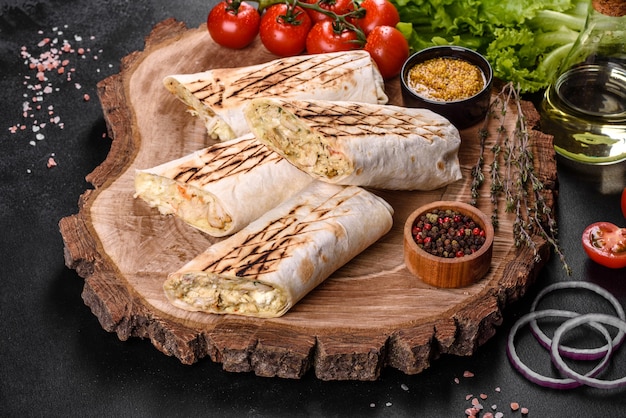 Delicious fresh shawarma with meat and vegetables on a dark concrete table. Fast food, Turkish cuisine