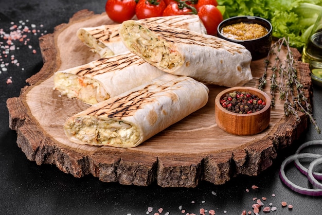 Delicious fresh shawarma with meat and vegetables on a dark concrete table. Fast food, Turkish cuisine