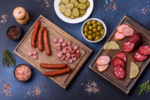 Delicious fresh smoked sausages cut with slices on a wooden cutting board