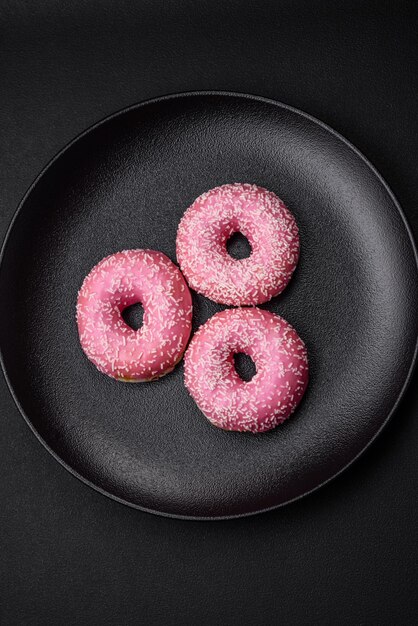 Delicious fresh sweet donuts in pink glaze with strawberry filling