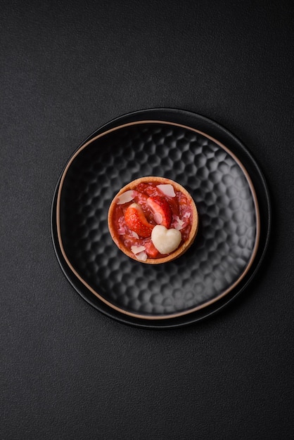 Delicious fresh sweet tartlets with strawberries and coconut flakes