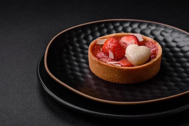 Delicious fresh sweet tartlets with strawberries and coconut flakes