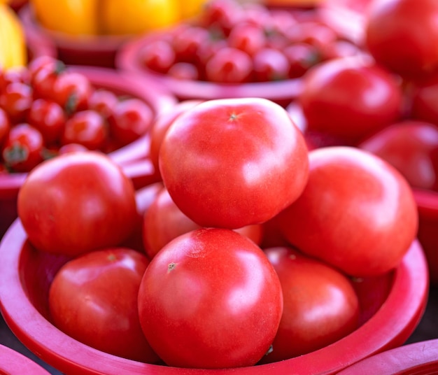 Delicious fresh tomatoes fruit vegetable food in red plastic basket at tradition market afternoon Seoul South Korea harvest concept close up