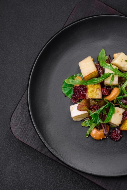 Delicious fresh vegan salad with pear brie cheese nuts and grains and arugula