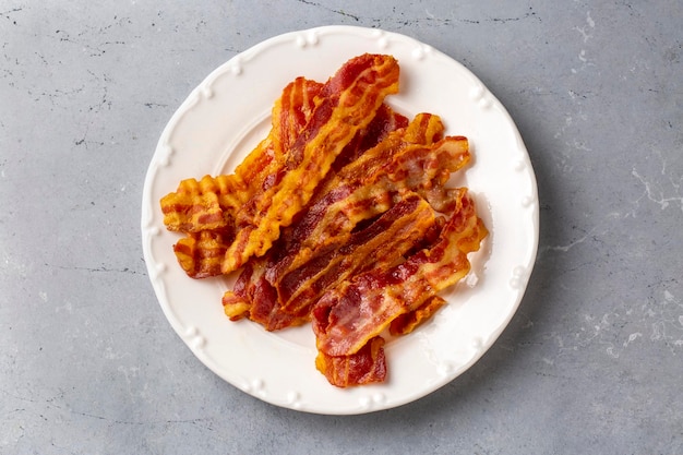 Delicious fried bacon served on plate.