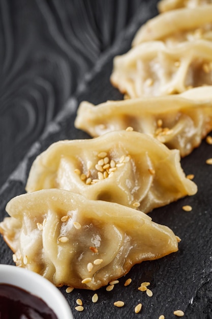 delicious fried gyoza dumplings on a black plate