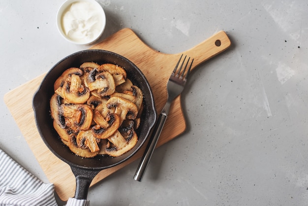 Delicious fried mushrooms with flat bread and herbs on the wooden table