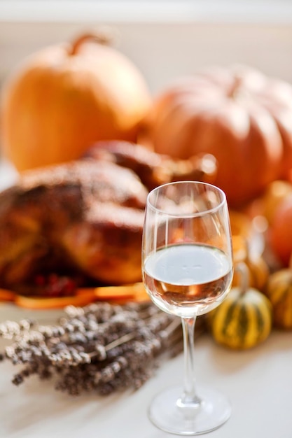 Delicious golden roasted Thanksgiving turkey on dinner table with pumpkins