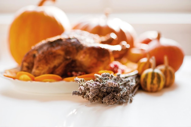 Delicious golden roasted Thanksgiving turkey on dinner table with pumpkins