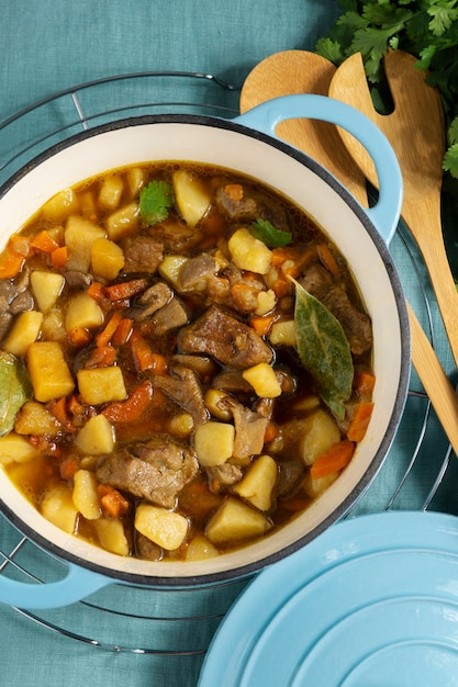 Delicious goulash and spoons on table